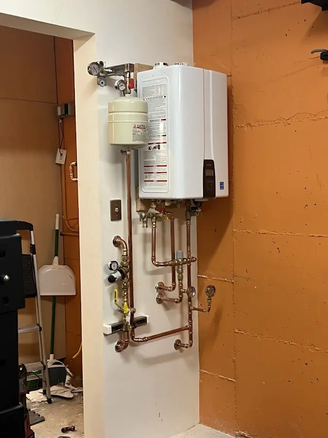 Plumbing technician inspecting water heater connections in Hendron